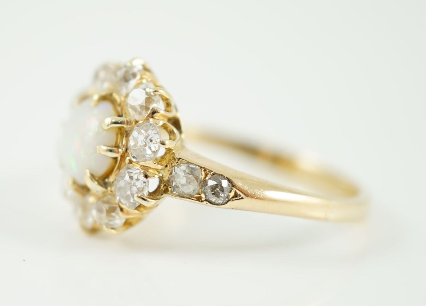 An early 20th century gold, white opal and diamond set circular cluster ring